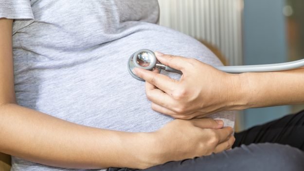 Hands of doctor examining a pregnant woman